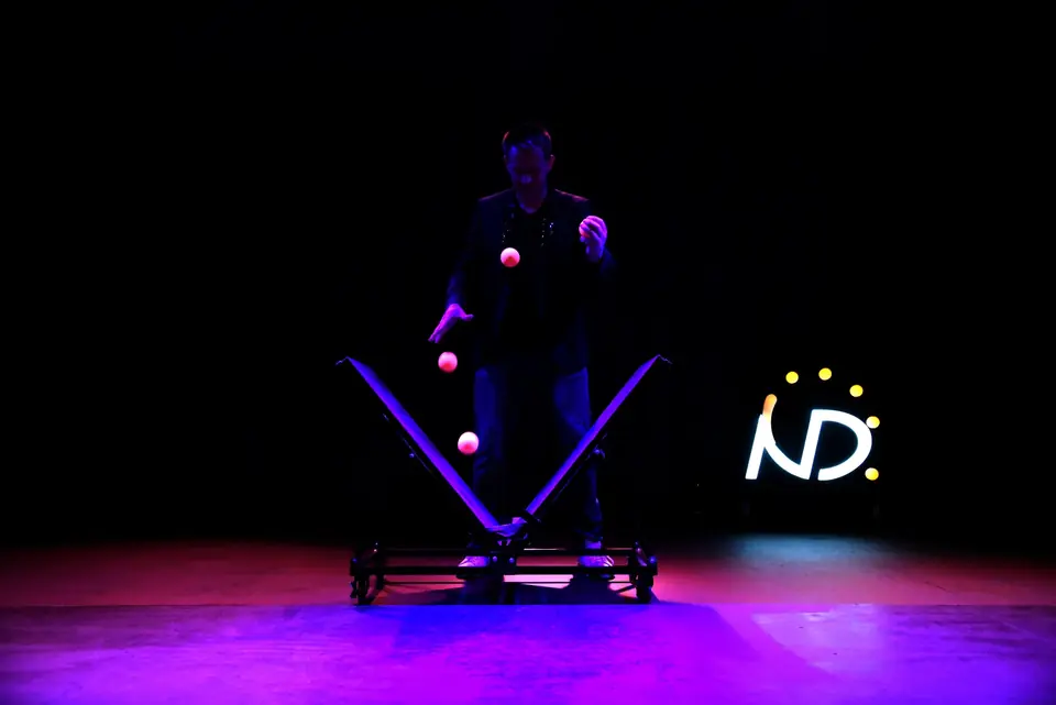Comedy juggler Niels Duinker under a single cool spotlight on the Wonders Theater stage